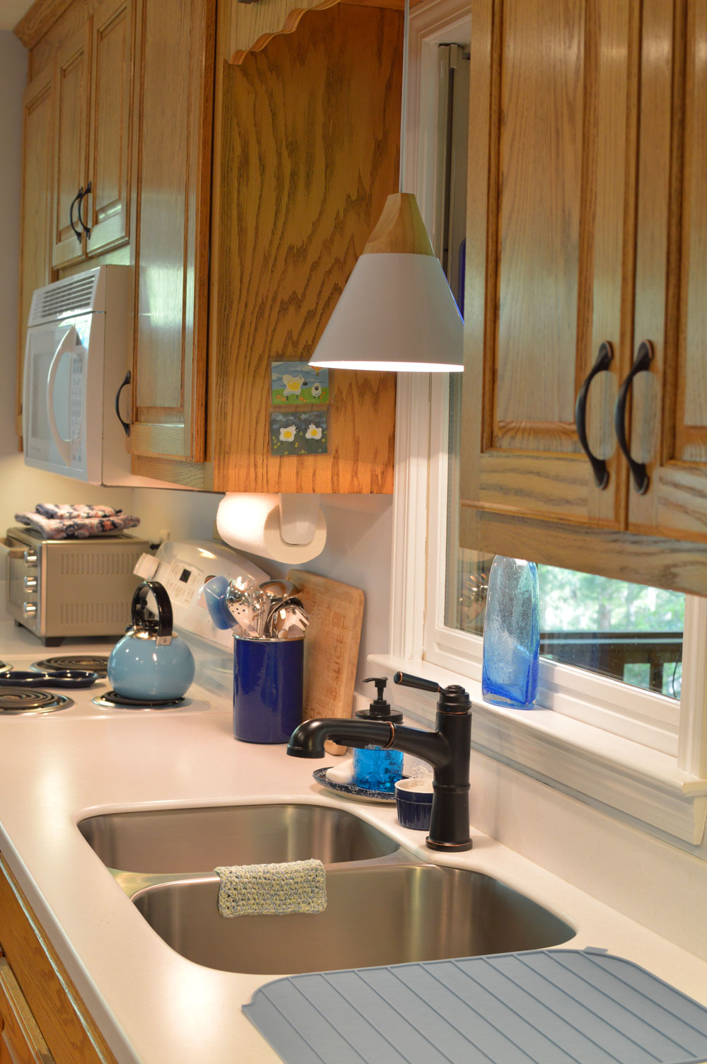 Oak-wood-cabinets-white-countertop-blue-walls-oiled-bronze-fixtures-hardware-kitchen-oak-floors-1